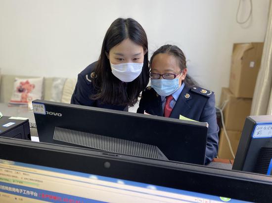 王普婷與同事一起核對享受優(yōu)惠行業(yè)企業(yè)數據