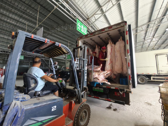 贵阳市农投集团捐助的9000斤新鲜猪肉抵达榕江,在物资接受点卸货。