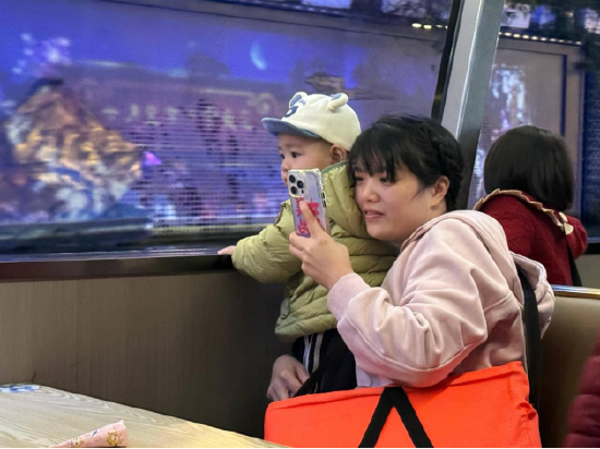 （图注：正在乘船夜游锦江的家长与孩子）