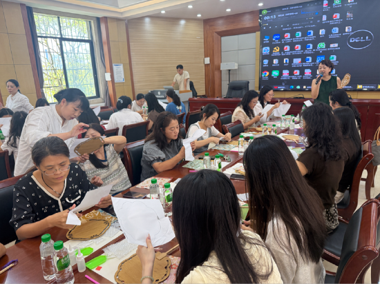 非遗大漆珍珠扇手作”教师节主题活动现场，教师们正认真裁剪扇子形状