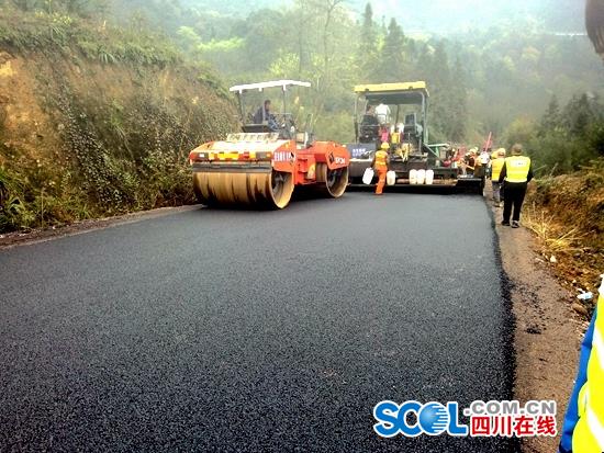 1号应急通道路面正在进行下面层施工铺设沥青。