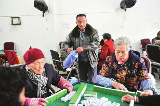 代师傅在茶馆里给大家掺茶倒水。