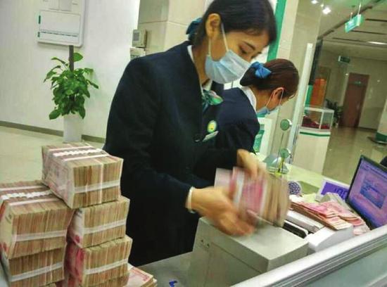 银行工作人员正在清点成捆的钞票
