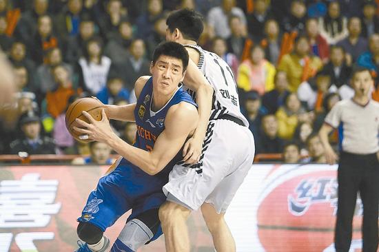 四川队球员张春军(左)在比赛中上篮。
