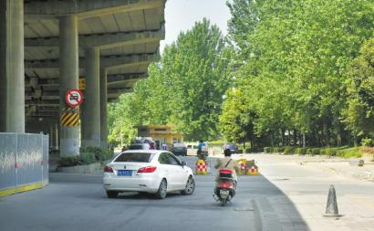 成都火车南站西路出城往机场主道被一道水泥墙阻断,辅道也立着隔离墩禁止机动车驶入。