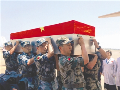 19日,在乌干达恩德培国际机场,中国军队工作组为烈士李磊、杨树朋灵柩举行起灵仪式 新华社发