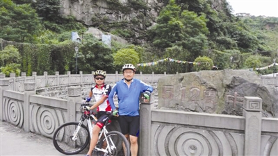 黄明富(右)和儿子黄肖宇在骑行途中
