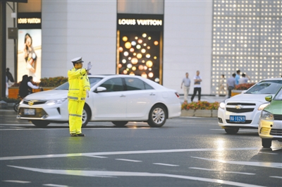 5日,人民南路红照壁路口, 交警穿着新配发的雨衣执勤。