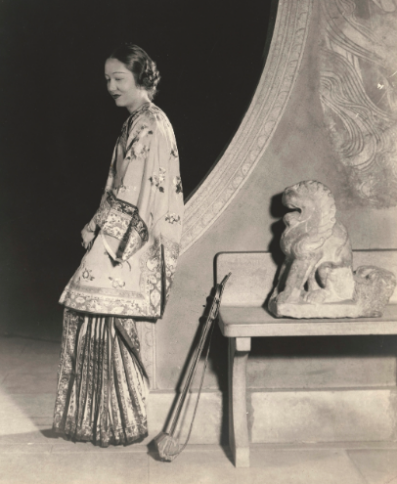 　　照片“北魏大型灰色石狮与卢芹斋（Ching Tsai Loo 1880-1957）之女”（A LARGE GRAY STONE FIGURE OF A SEATED LIONNORTHERN WEI DYNASTY AND DAUGHTER OF Ching Tsai Loo），图片版权：苏富比拍卖