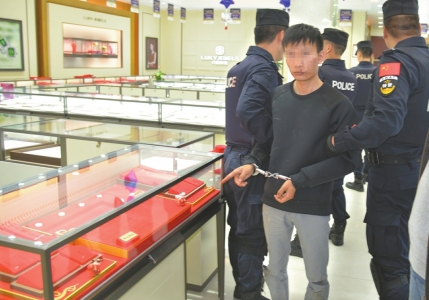 10月18日,犯罪嫌疑人在事发珠宝店指认作案现场。