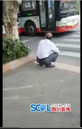约60岁男子尊在马路边,随后钻入公交车底身亡(视频截图)
