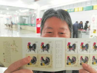 市民彭淑云展示购买到的生肖邮票。