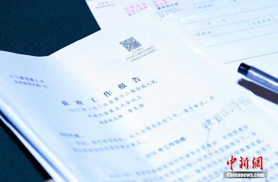 3月6日,一份摆放在政协委员桌上的政府工作报告。今年政府工作报告文本上首次印上二维码。中新社记者 侯宇 摄