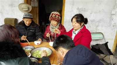 一家团圆后,王德林(左一)和家人一起吃饭