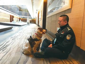 结束场馆安检工作后,民警和警犬坐在地上休息