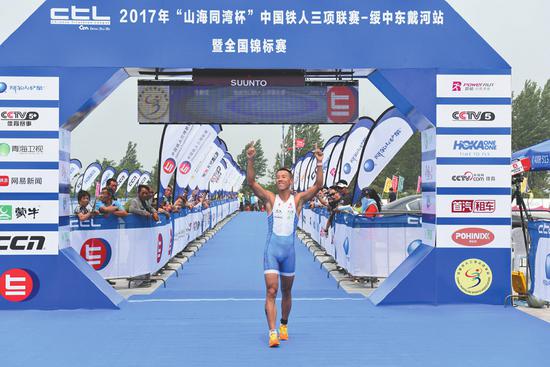 铁三项目第三项长跑。图为拿下全运会专业组参赛资格冲线时，李鹏程振臂庆祝这历史性一刻。