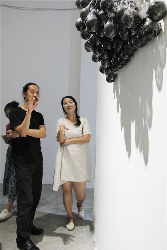 艺术家雪芹子和艺术家周斌在作品《无明》旁边