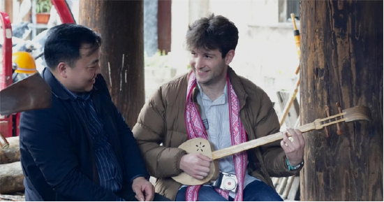 合唱团成员向传承人学习侗族乐器