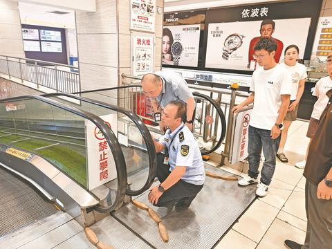 工作人员对商场自动扶梯进行安全“体检”。 （大竹县市场监督管理局供图）