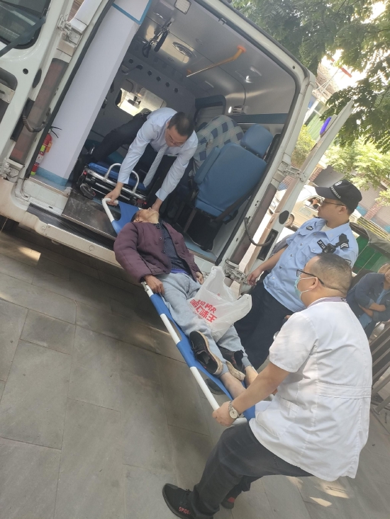 廖維國和同事配合將老人抬上救護車