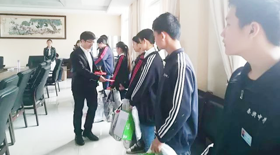 极客数学帮校长祝明向学生分发助学物资