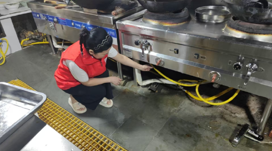 图为:工作人员排查辖区餐饮店、居民燃气安全隐患