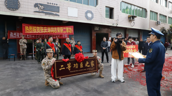 军地一行人为现役军人张庆涛同志送二等功喜报，家人代为接收