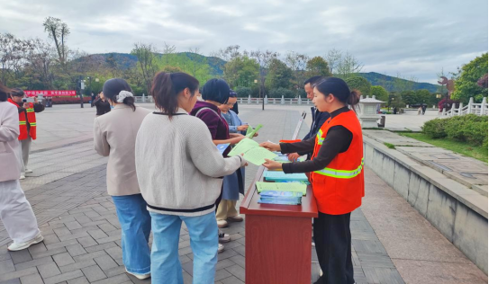 图为：街道工作人员和社区志愿者发放活动宣传手册