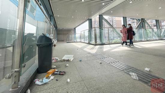 行人從天橋上爆滿的桶旁經過