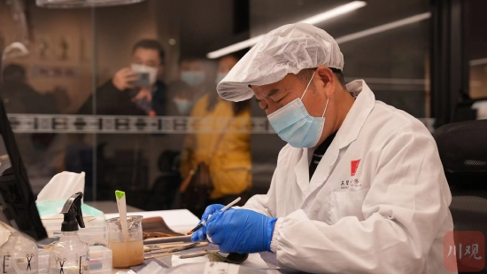 郭漢中在清理青銅面具上的浮土