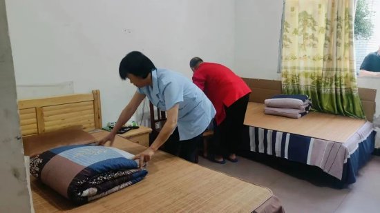 护工为老人整理床铺