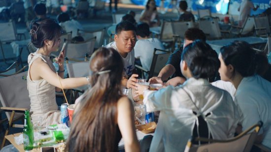 人们围聚,在夜色里一边听音乐享美食