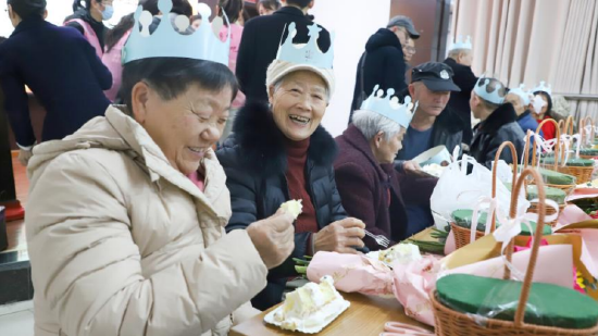 集体生日会上，老人们喜笑颜开，共同品尝生日蛋糕