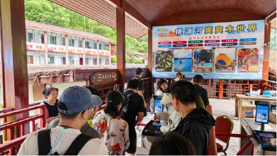 游客们在桃源河景区刷脸入园
