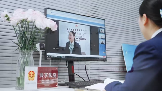 图为：金华中支工作人员通过金融“共享法庭”云端调解