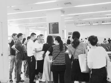 位于成都后子门的房产交易中心大厅内,购房者正在办理相关业务。