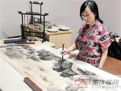 杨雪梅对带去北京的画进行最后润笔。