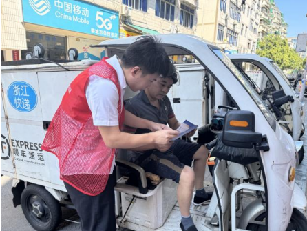 图为太平人寿员工在快递站点向顺丰快递员讲解金融知识