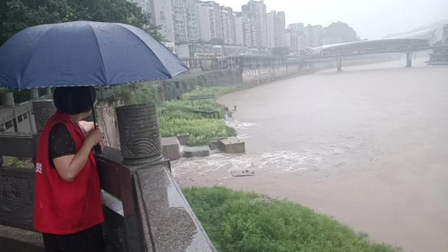 草街子社區安全員在仙鶴路廣場實時查看州河水位情況