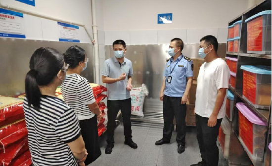 图为：检查组在达川中学查看食堂后厨情况