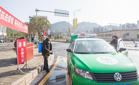 雅安汽车客运站外,工作人员对出租车进行消毒