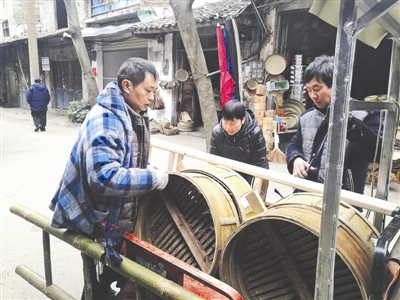 任祖国(左一)正在将预备发货的蒸笼搬上车