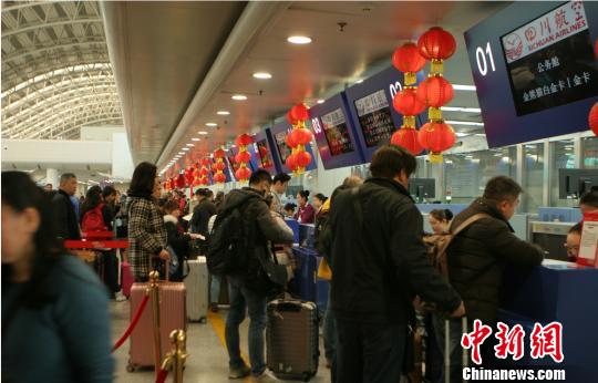 图为旅客等待托运行李。 吕俊明 摄