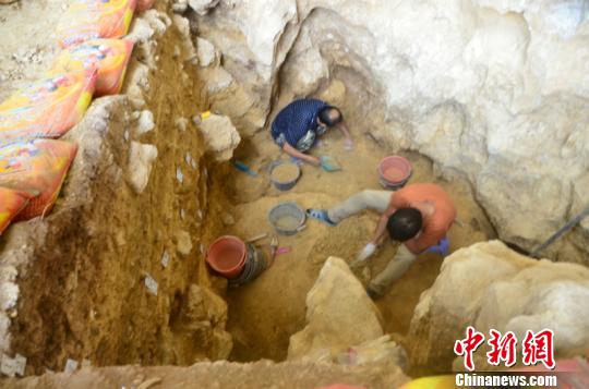 图为工作人员在清理遗址 钟欣 摄