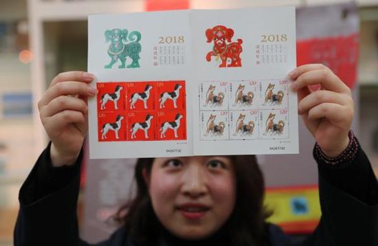 1月5日，在浙江省宁波市一邮政网点，工作人员展示《戊戌年》生肖邮票小版张。 新华社 图