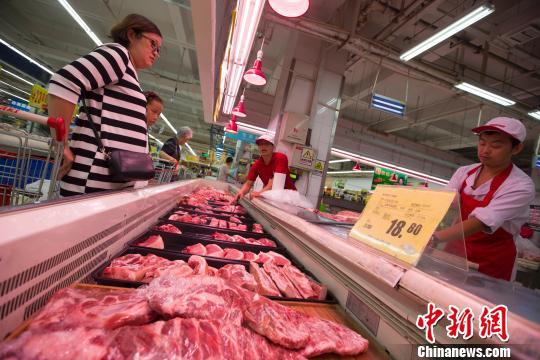 資料圖:民眾在超市購買豬肉。 張?jiān)?攝
