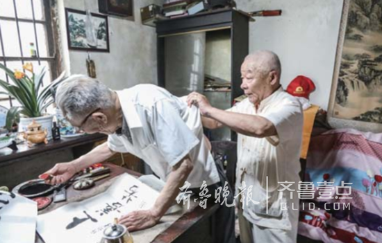 刘茂临帮何静园老人挠痒痒。 记者 李岩松 摄