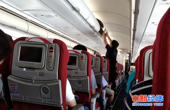 乘客在飞机上整理行李 中新经纬熊家丽 摄