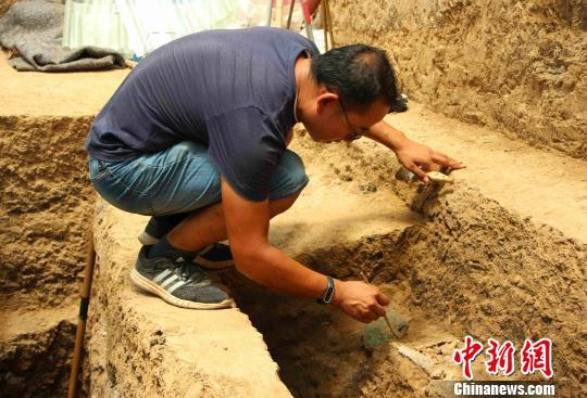 考古人员正在紧锣密鼓地清理和发掘文物。　赵晓 摄