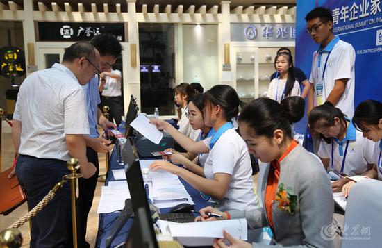 青年企業(yè)家在志愿者的幫助下辦理簽到及入住手續(xù)